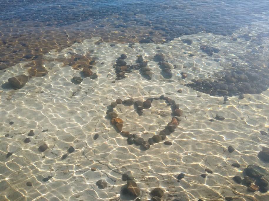 "Hi" written in rocks underwater.